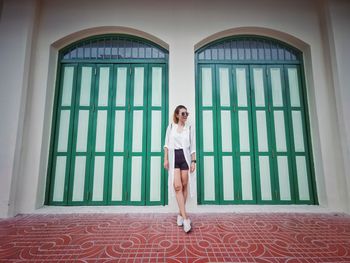 Full length of woman standing by window of building