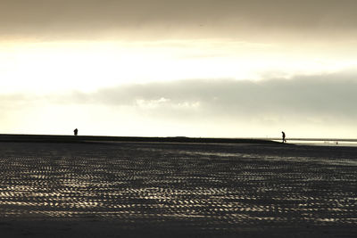 Silhouette person on field against sky