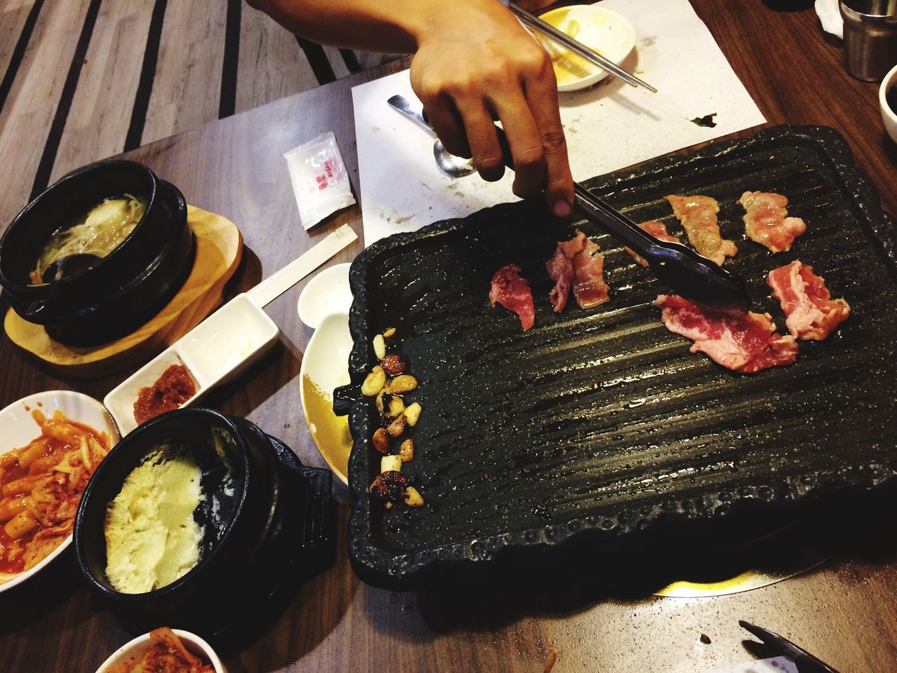 food and drink, food, freshness, indoors, person, meat, preparation, preparing food, ready-to-eat, healthy eating, indulgence, high angle view, cooking, table, holding, meal