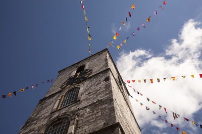 Low angle view of flags on church building against sky, cork