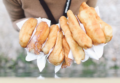 Midsection of person holding donuts