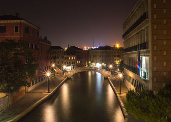 Illuminated canal in venice at night