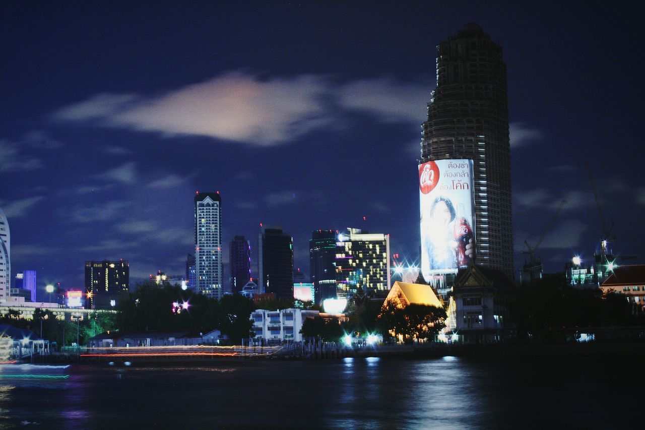 city, skyscraper, illuminated, urban skyline, night, architecture, building exterior, city life, modern, travel destinations, cityscape, tower, multi colored, river, financial district, downtown district, no people, outdoors, office building exterior, sky, nightlife, water