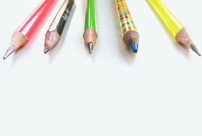 High angle view of colored pencils against white background