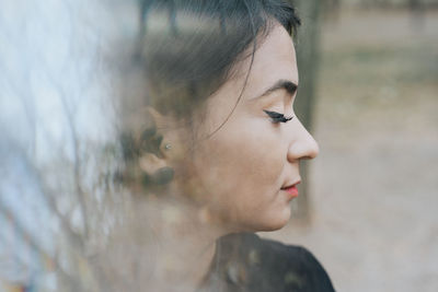 Close-up of young woman with eyes closed outdoors