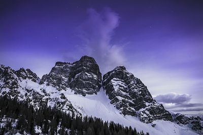 Low angle view of mountains against purple sky