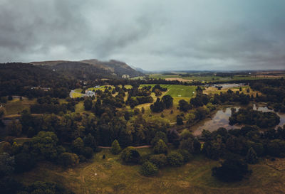 Aerial view of misty scotland hills trails river and forest