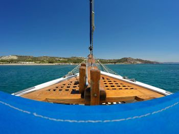 Close-up of wooden post in sea against clear blue sky