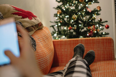 Low section of person resting on sofa during christmas