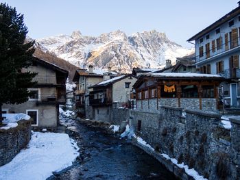 Snow covered houses and mountains against clear sky