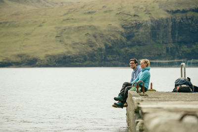 Rear view of people on lake against mountain