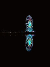 Illuminated ferris wheel at night