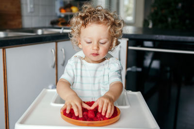 Cute boy looking at food at home