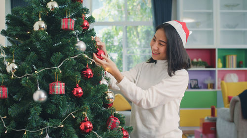 Midsection of woman with christmas tree