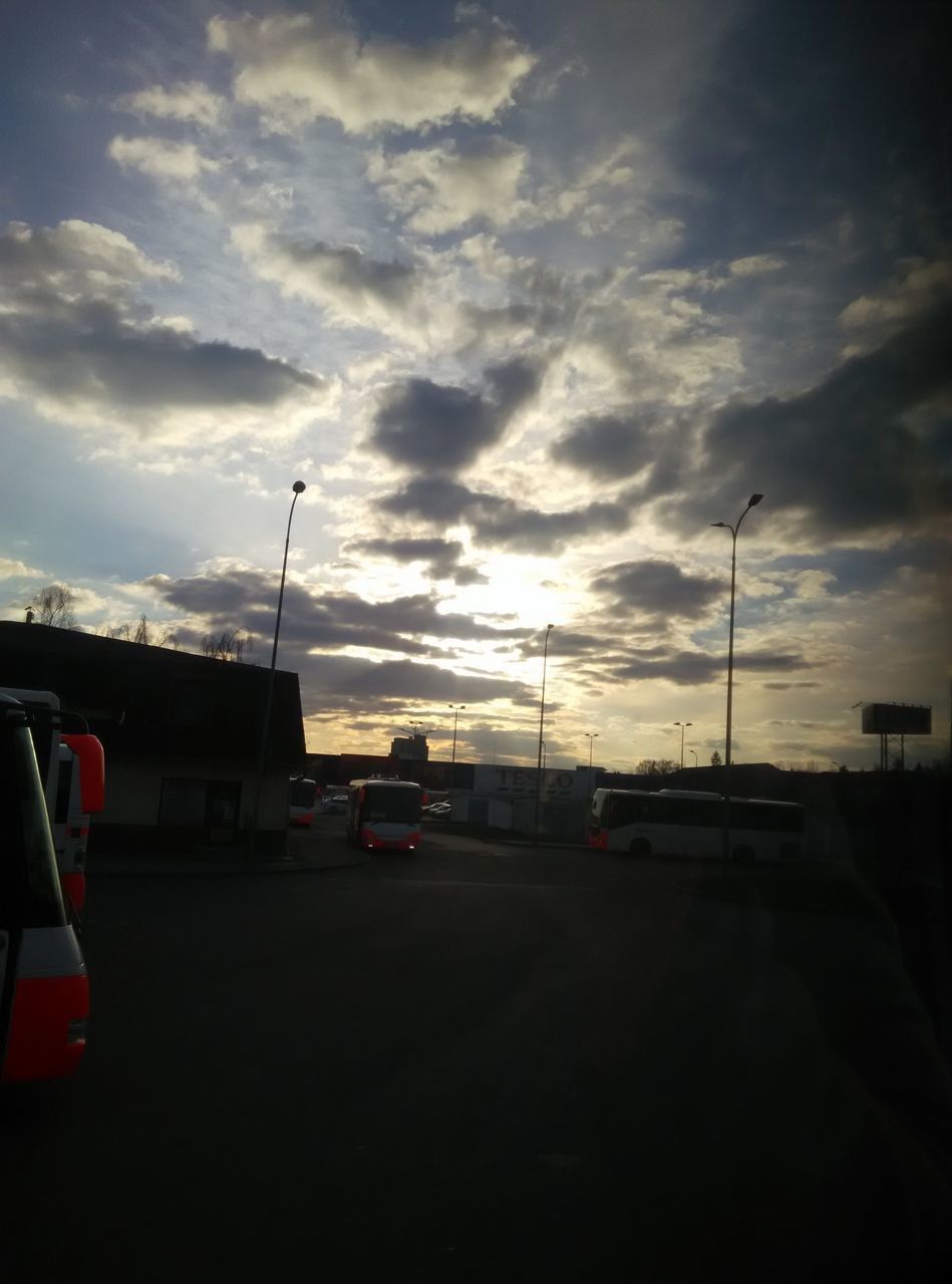 transportation, car, sky, land vehicle, mode of transport, cloud - sky, road, sunset, street, street light, cloudy, cloud, on the move, silhouette, travel, the way forward, outdoors, road marking, dusk, traffic