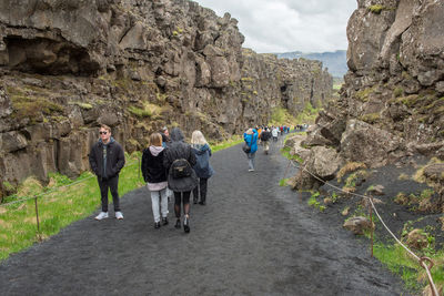 Rear view of people walking on rocks