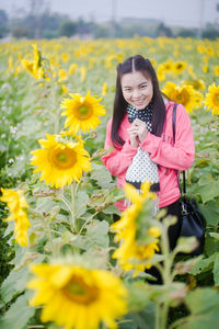 Portrait of woman standing on sunflower field