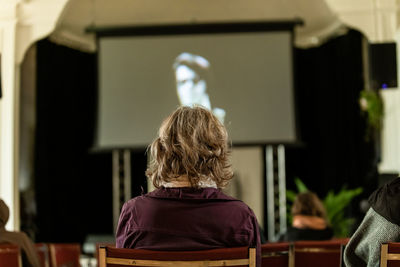 Rear view of woman sitting on chair