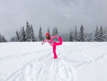 Woman wearing pink winter clothes having fun in winter