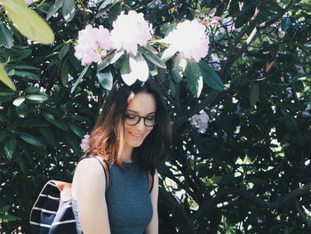 Portrait of young woman against plants