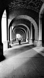 Rear view of person walking in corridor of building