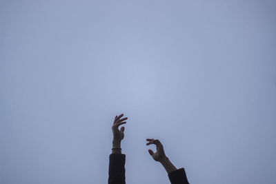 Low angle view of person hand against clear sky