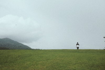 Man standing on field against sky