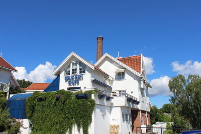 Low angle view of houses against blue sky