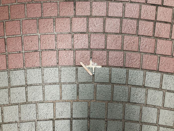 Close-up of arrow sign on brick wall