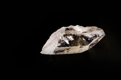 Close-up of snow on rock against black background