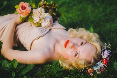 Portrait of young woman lying on grass