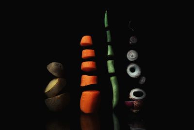 Sliced vegetables in mid-air against black background