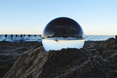 Surface level of rocks on beach against clear sky