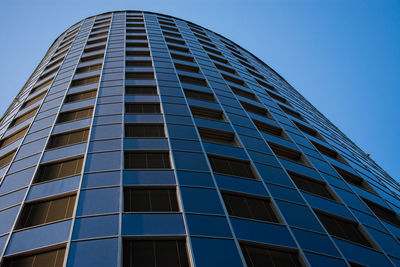 Low angle view of modern building against clear blue sky