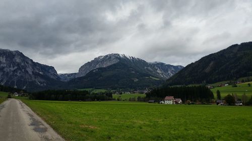 Scenic view of field and mountains against sky