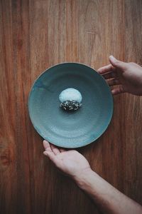 Directly above shot of person holding ice cream on table