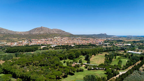 Aerial view of townscape against clear blue sky