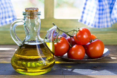 Close-up of oil in jug by tomatoes