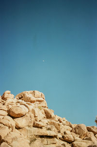 Low angle view of rock formation against clear blue sky