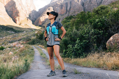 Full length of young woman standing on mountain