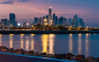 Illuminated buildings in city against sky at night