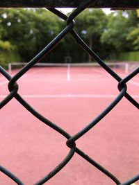 Tennis court seen through chainlink fence