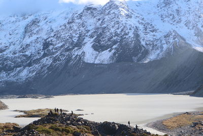Scenic view of lake by mountain during winter