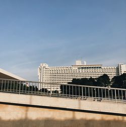 Bridge over buildings in city against sky