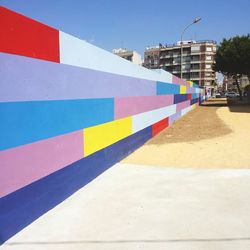 Multi colored built structure on beach against blue sky