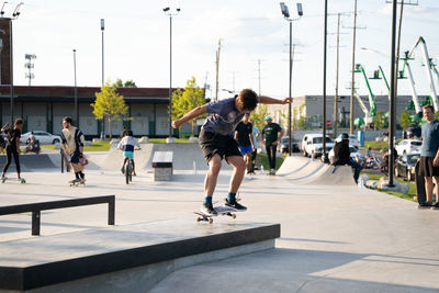 Full length of man skateboarding on city street