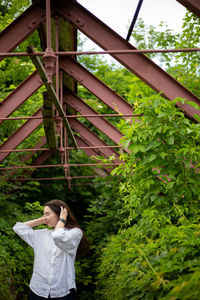 Portrait of young woman standing against building