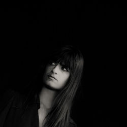 Portrait of a beautiful young woman over black background