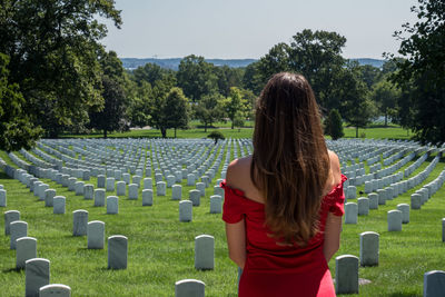Rear view of woman standing in cemetery