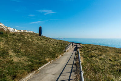 Scenic view of grassy landscape against blue sky